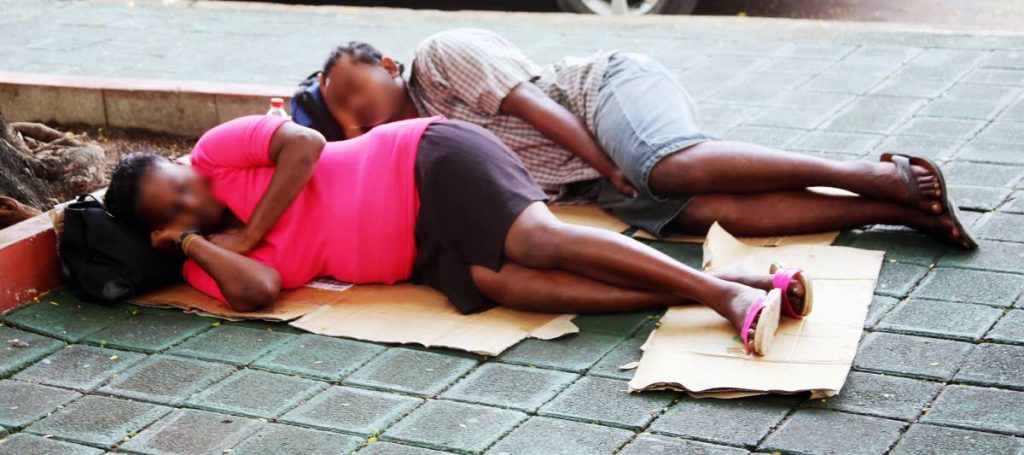 Two homeless people sleep on a piece of cardboard at Harris Promenade.  - 