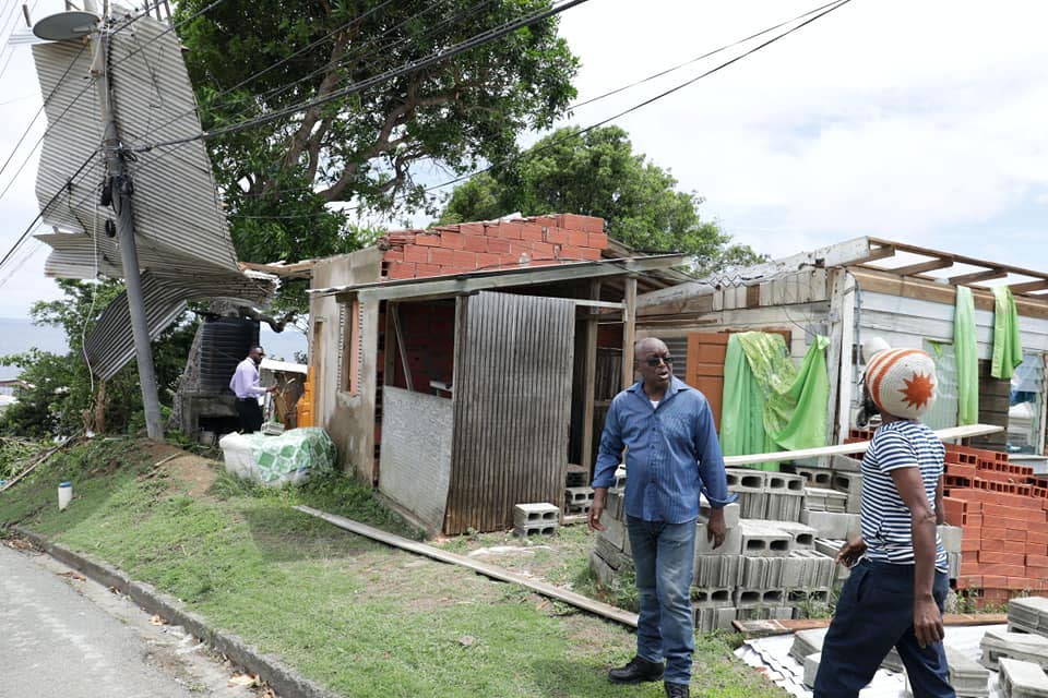 Weston Robley, right, talks with THA Chief Secretary Kelvin Charles as they view the damage done to his home at Paul Street, Goodwood, on September 23.