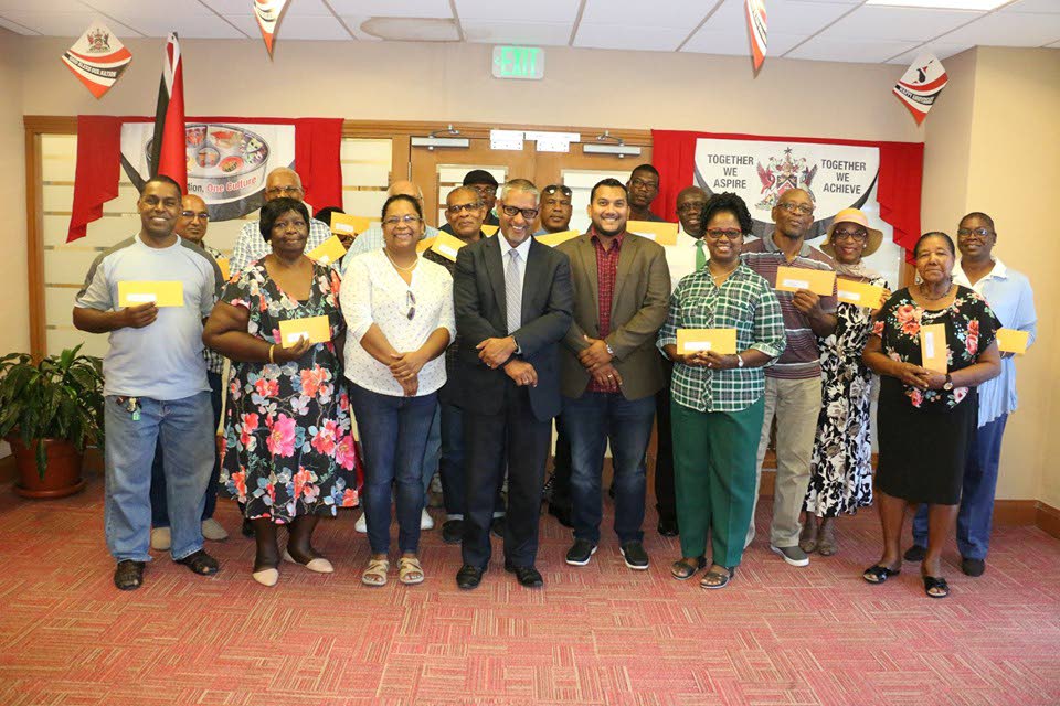 Clarence Rambharat, centre,  Minister of Agriculture, Land and Fisheries and senator Avinash Singh (on Rambharat’s right side)  with recipients of leases in Chaguanas on Tuesday. PHOTO COURTESY THE MINISTRY OF AGRICULTURE, LANDS AND FISHERIES 