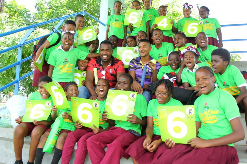 Students of Chinapoo Government Primary with TKR players Darren Bravo and Mark Deyal on Tuesday. 