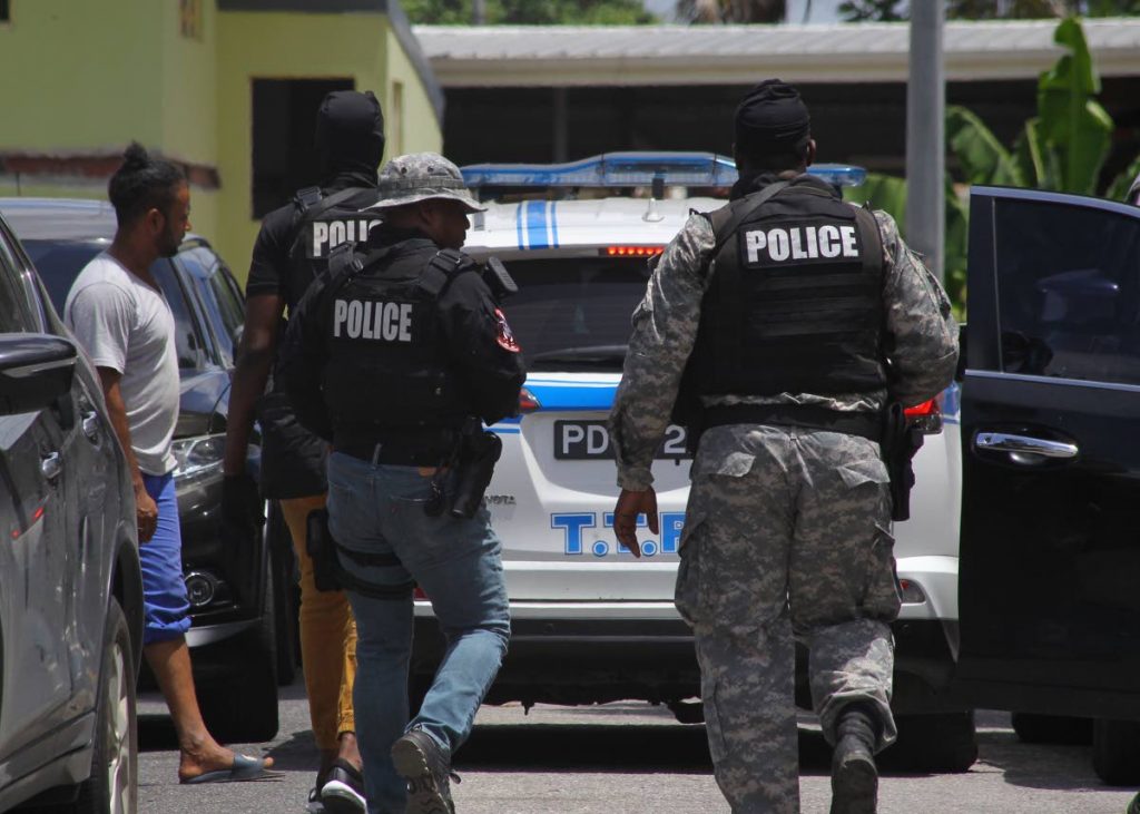 IN CONTROL: Police who arrived on the scene at Malabar in Arima and rescued a woman and her daughter who were being held hostage in their home by a male relative. 