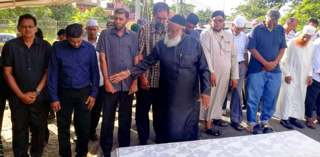 Members of the Mandingo / Realize Road jamaat, led by Imam Najib Hosein, pray over Azard Ali's body. PHOTO BY SEETA PERSAD