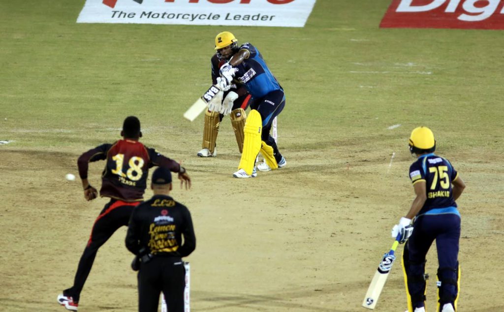 Barbados Tridents opener Johnson Charles drives against TKR left-arm spinner Khary Pierre during Wednesday's encounter. PHOTO BY SUREASH CHOLAI.