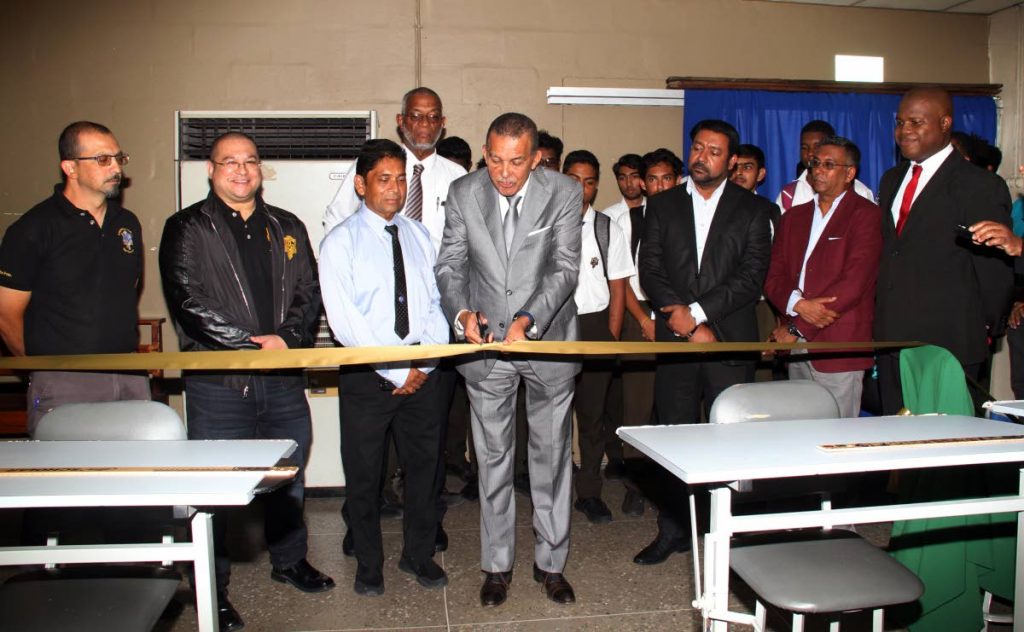 Former President Anthony Carmona, centre, cuts the ribbon to open an auto cad technical lab at
 Presentation College, San Fernando on Thursday. 