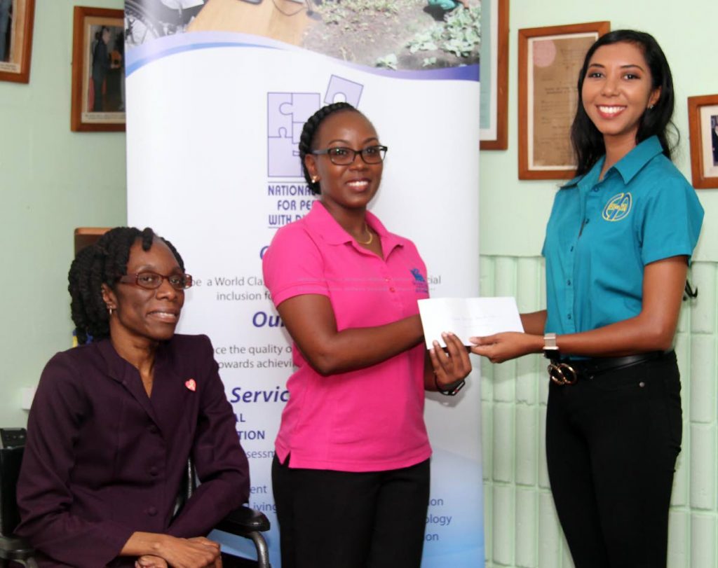National Centre for Persons with Disabilities (NCPD) programme manager Giselle Ramose, centre, receives a cheque from health and safety manager of Fides Ltd Karen Lopez alongside NCPD executive assistant secretary Renese Jardine at the centre on New Street, San Fernando on Friday. PHOTO BY VASHTI SINGH