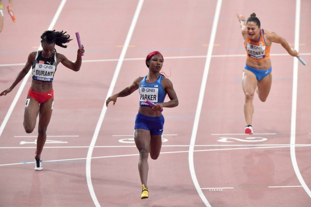 Trinidad and Tobago’s Kamaria Durant, United States’ Kiara Parker and Netherlands’ Naomi Sedney (from left) cross the finish line in the women’s 4x100 metre relay at the World Athletics Championships in Doha, Qatar, yesterday. AP PHOTO