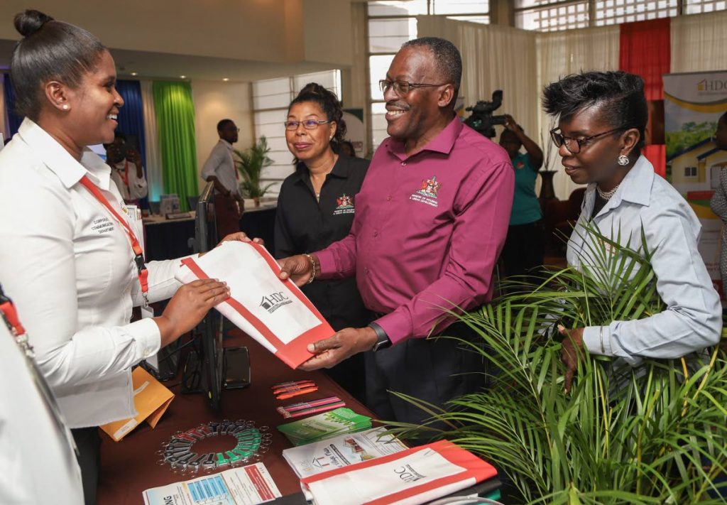 Housing Minister Edmund Dillon interacts with HDC staff at the Housing 101 Expo held by the Ministry of Housing at Hilton Trinidad, St Ann's yesterday. PHOTO BY JEFF K MAYERS 