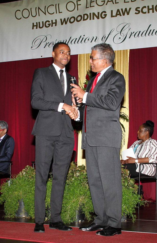 WELL DONE: Kadeem Williams is presented with his Legal Education Certificate from Council of Legal Education chairman Reginald Armour SC at a graduation ceremony for Hugh Wooding Law School students at UWI Spec on Saturday.  PHOTO BY ANGELO M MARCELLE