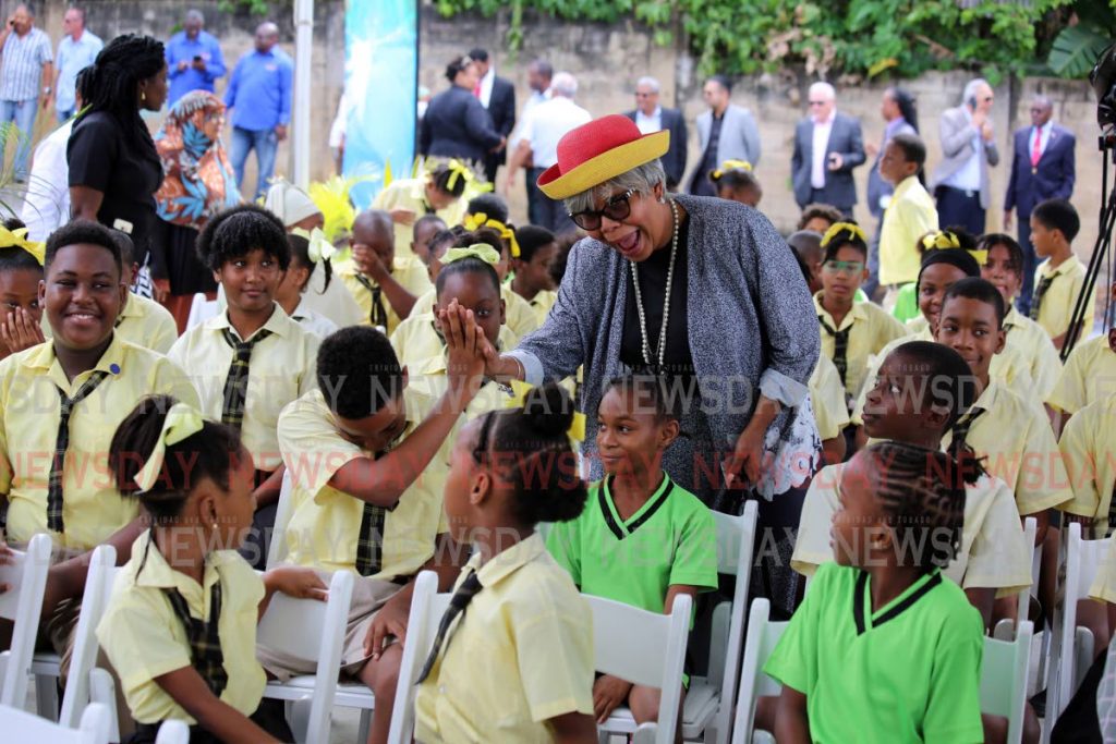 TELL GRANNY: Actress Nikki Crosby interacts with students of the Four Roads Primary School during the opening of the walkover in Diego Martin on Tuesday.  PHOTO BY SUREASH CHOLAI