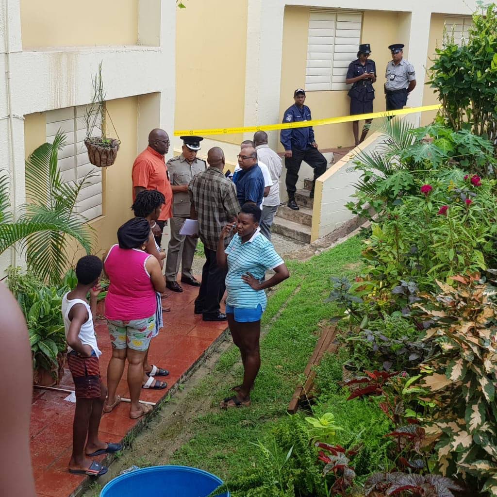 Snr Supt Wayne Mohammed with residents of Building C, Embacadere, where Ezekiel Daniel was murdered last night