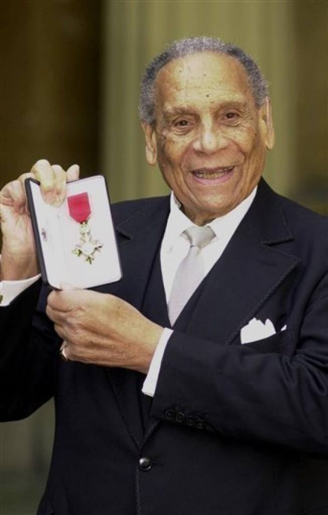 A March 21, 2000, file photo of band leader Edmundo Ros after receiving an OBE for services to entertainment during an investiture ceremony held at Buckingham Palace, London. (AP Photo/John Stillwell/PA) 