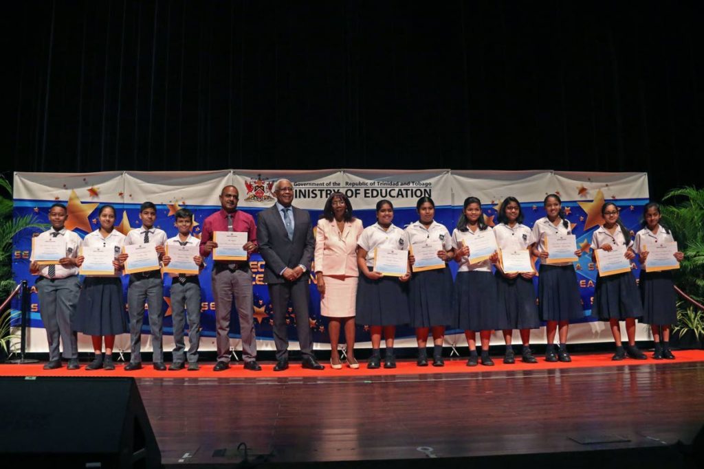Education Anthony Garcia and adviser Cheryl Ann Wilkinson poses with the  SEA graduates and an official of Grant Memorial Presbyterian School during a recognition ceremony for the top 200 SEA students at SAPA, San Fernando. PHOTO BY MARVIN HAMILTON