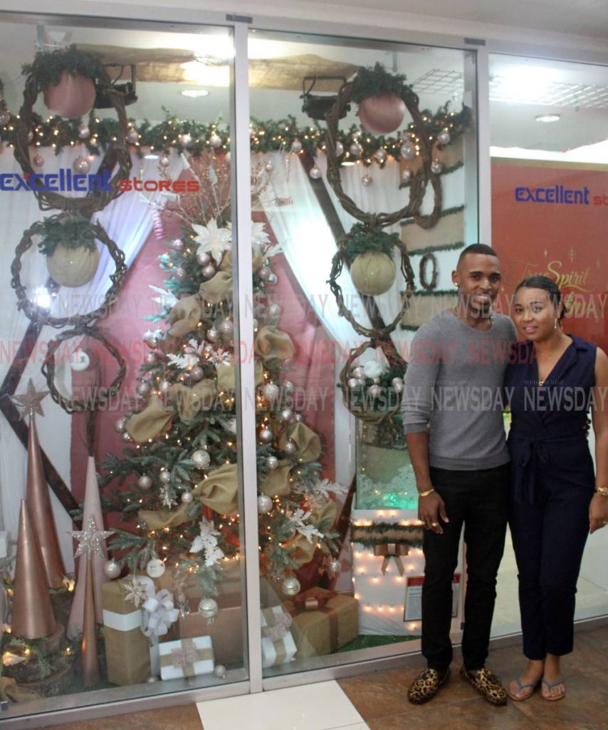 Denzel & Kimberly Mc Meo, stand next to their Rustic Christmas window decoration, which they revealed with other persons who competed in the Excellent Stores Window Revel competiton. Windows were revealed at the Trincity Mall Branch on Friday. Winners would be announced in November.

PHOTO:ANGELO M. MARCELLE - ANGELO_MARCELLE