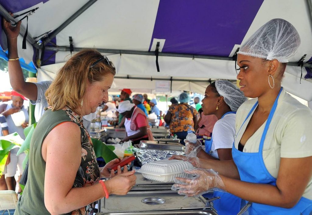 A woman buys some of the unique dishes at Blue Food Festival on Sunday.  - Division of Tourism & Culture
