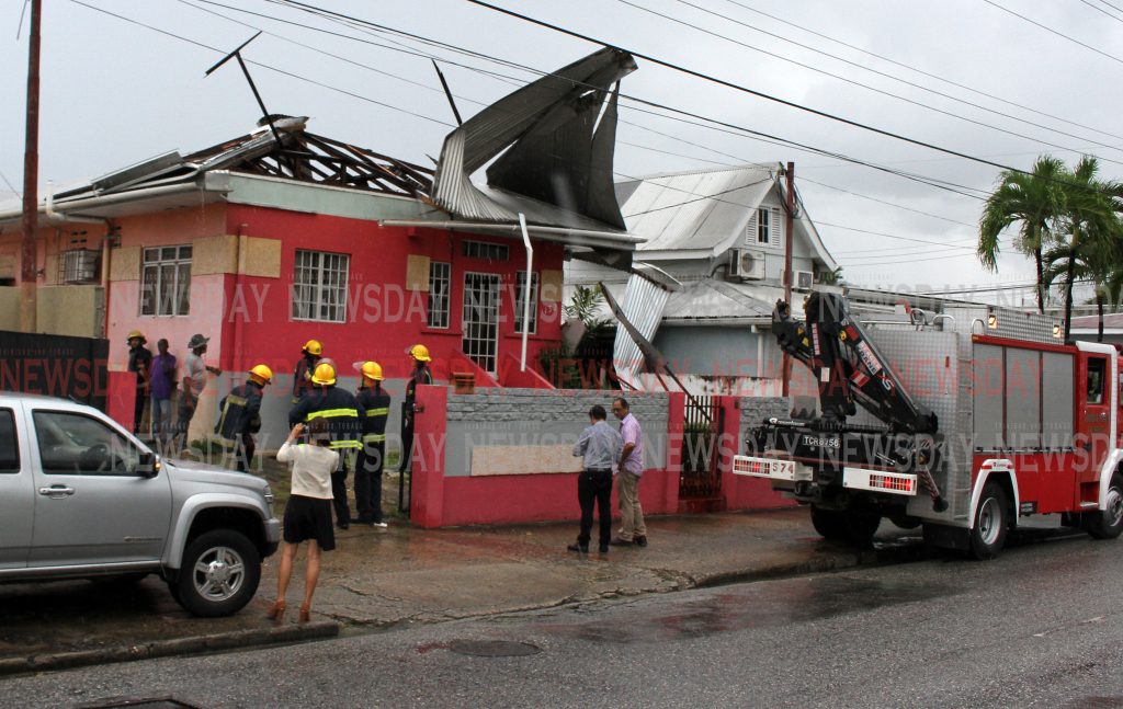Fire Officers on the scene where strong winds blew off the roof of Firesec Ltd Security Company on Wrightson Road, Port of Spain yesterday. 

PHOTO:ANGELO M. MARCELLE

