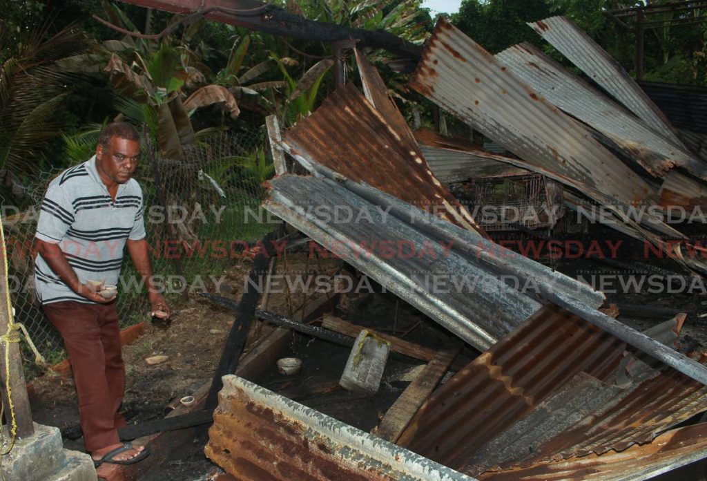 Baldeo Sookgrim picks up the deyas that remain after his home was destroyed by a fire on Sunday at Rochard Road, Barrackpore - CHEQUANA WHEELER