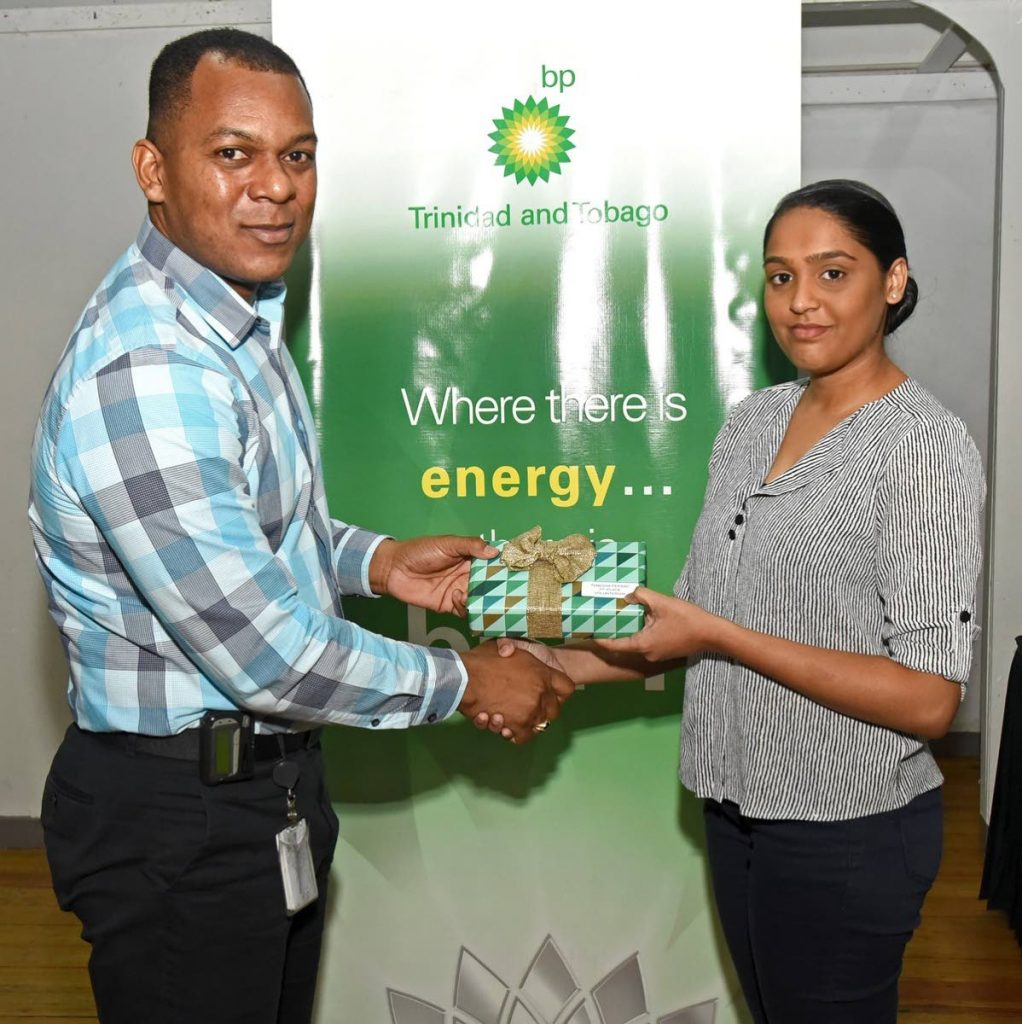  Joel Primus of BPTT presents a token to Brighter Prospects student Tenecia Persad for completing 65 hours of volunteerism. - 