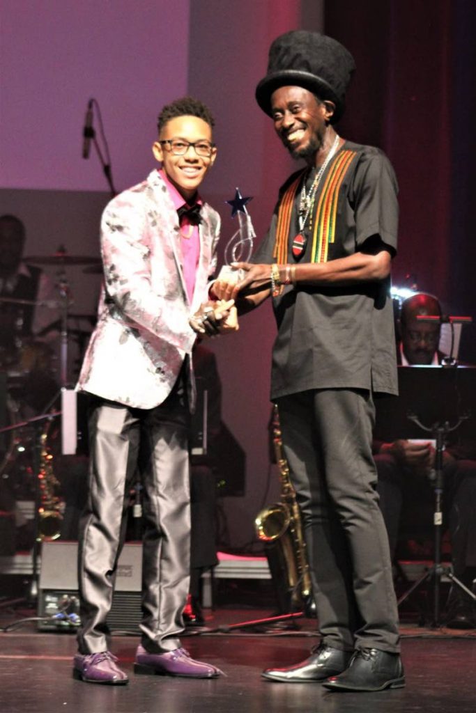 Aaron Duncan is presented with the  Junior Calypso Achiever Award from TUCO president Lutalo  Masimba. - Gary Cardinez