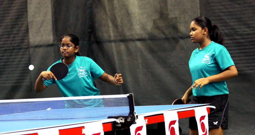 Ashlea Mohammed (L) and Lyllana Boodan, of Tunapuna Hindu Primary School, take part in a girls double match,at the Scotiabank Schools Table Tennis Tournament,at the National Racquet Centre,Tacarigua,yesterday. - SUREASH CHOLAI
