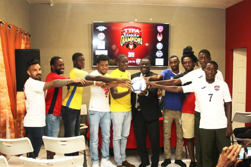 TT Football Association chairman Selby Browne (C) and players of various teams touch a football during the launch of the TTFA’s League of Champions tournament, which kicks off on Sunday. - Lincoln Holder