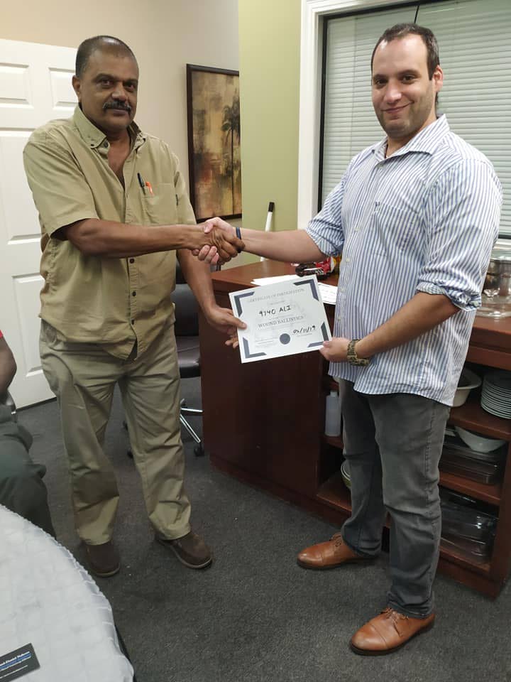 Court and Process Officer Sgt Ali, left, receives his certificate of completion from Chief Training Officer of the Blue Line Law Enforcement Academy Paul Nahous, on Saturday after a ballistic wound training course on Woodford Street, Port of Spain.   PHOTO COURTESY BLUE LINE LAW ENFORCEMENT ACADEMY - Shane Superville