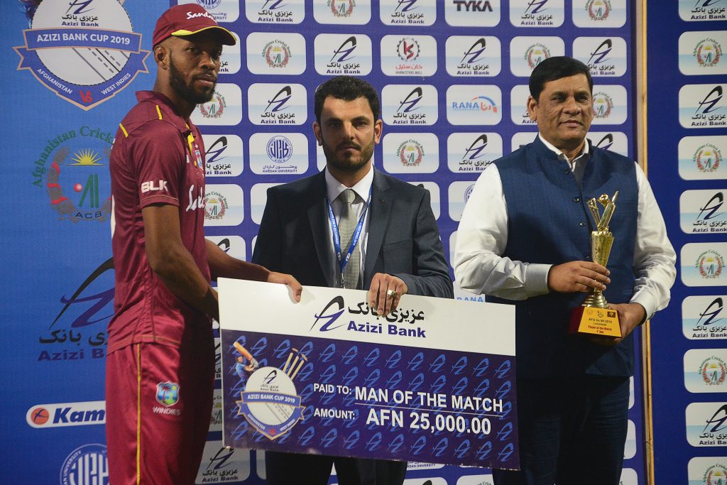 West Indies' Roston Chase (L) receives the 'man of the match' award check after the first one day international (ODI) cricket match between Afghanistan and West Indies at the Ekana Cricket Stadium in Lucknow on November 6, 2019. (Photo by Rohit UMRAO / AFP) / ----IMAGE RESTRICTED TO EDITORIAL USE - STRICTLY NO COMMERCIAL USE-----