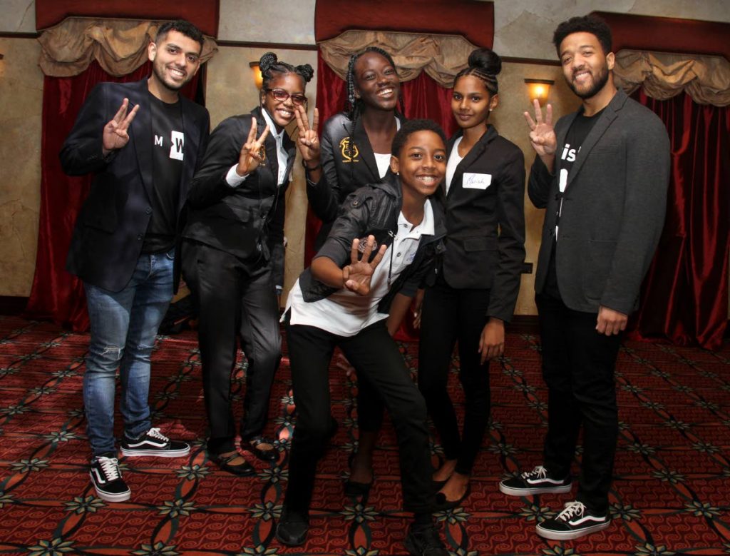 Motivational speakers and facilitators of the WE Youth Conference Joseph Flores, left, and Jalen Nicholson take a photo with students of El Dorado West Secondary School at the The Banquet and Conference Centre Movietowne on Wednesday.  - Ayanna Kinsale