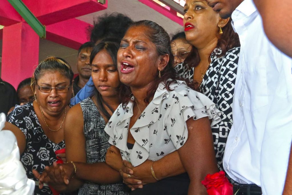 Vidiay Ramkissoon and relatives weep as they say farewell to the late Ravi Ramkissoon at his funeral in Basta Hall, Couva, yesterday. - Marvin Hamilton