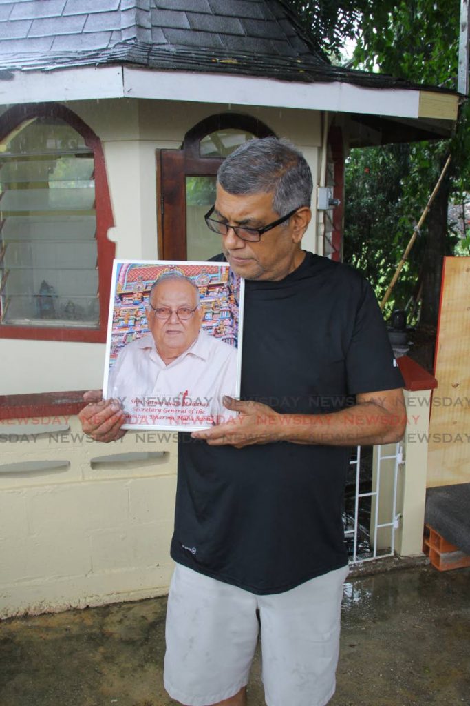 Vijay Maharaj holds a portrait of his late father Satnarayan 