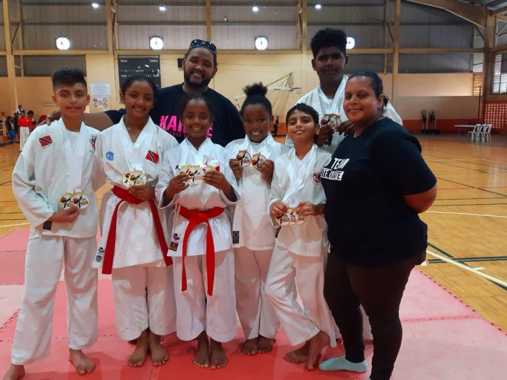 Team Elite coaches Barry and Lena Winter pose with their charges after the ISKA Martial Arts Championship at the Eastern Regional Indoor Sports Complex in Tacarigua, earlier this month.  - 