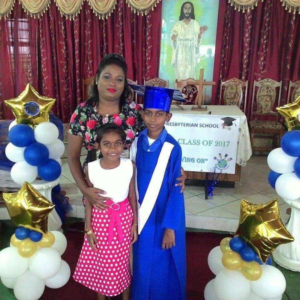 Ronaldo Narine wears one of the gowns at the 2019 SEA graduation at Rousillac Presbyterian Primary, standing with him is his sister Ameisha and his mother  PTA vice president Jennelle Narine.
 - 