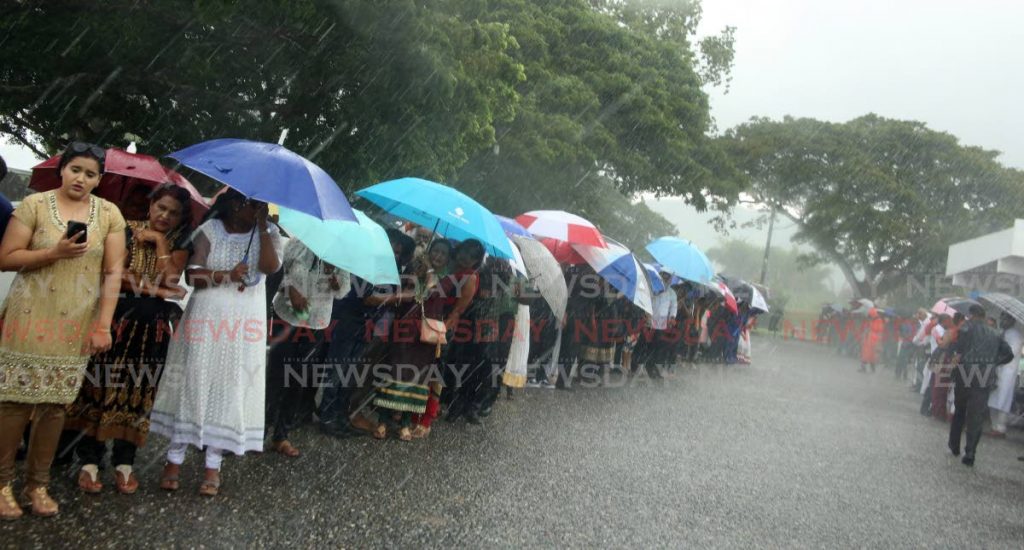 Mourners endure the pouring rain to witness the cremation of the former secretary general of the Sanatan Dharma Maha Sabha, Satnarayan 