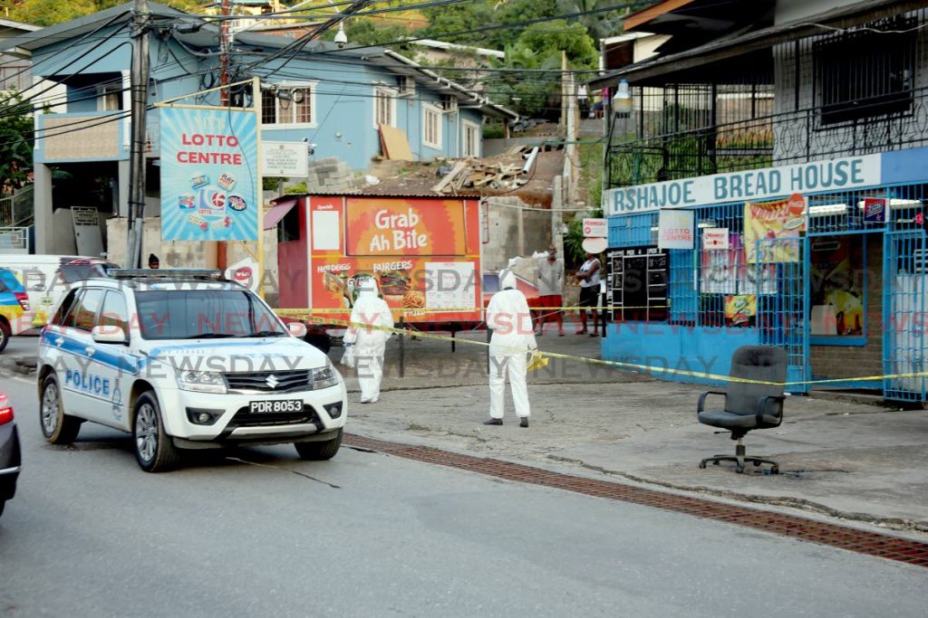 Police process the scene at which a mother and her son were shot on the corner of Saddle Road and Santa Cruz Old Road, San Juan, yesterday. - SUREASH CHOLAI