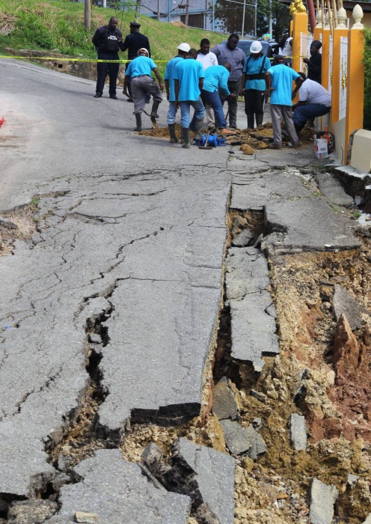 A WASA crew makes emergency repairs near a landslip Wharton Road Extension, in Trou Macaque, Laventille, yesterday. - ROGER JACOB