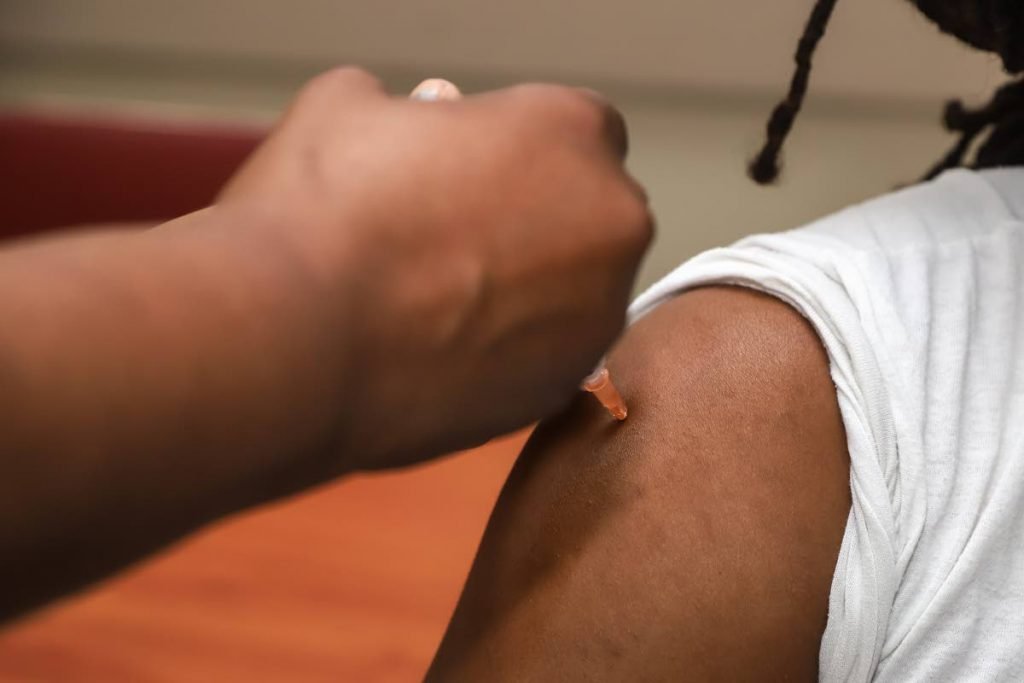 The flu vaccine is given to a man. 
