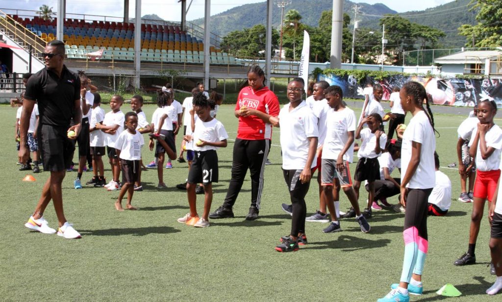 Olympic gold medallist Keshorn Walcott (L) and TT sprinter Khalifa St Fort,2nd from right, spend time with primary school athletes, on Sunday, at the Atlantic Track and Field Development camp,held at the Marvin Lee Stadium, Centre of Excellence,Macoya. - ANGELO_MARCELLE