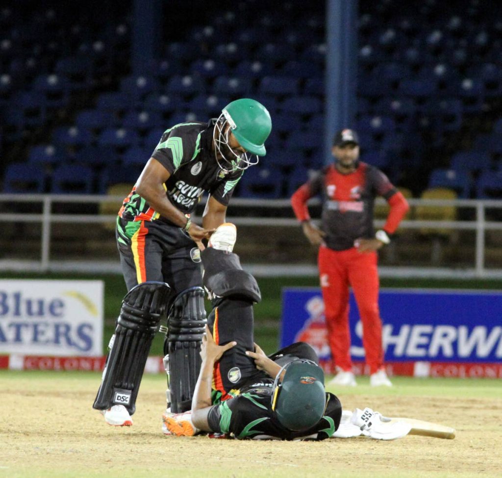 Guyana Jaguars’ Veerasammy Permaul (L) assists team-mate Jonathan Foo after the latter picked up a strain during the Colonial Medical Insurance Super50 match against the TT Red Force, at the Queen’s Park Oval, St Clair, on Saturday. - Angelo Marcelle