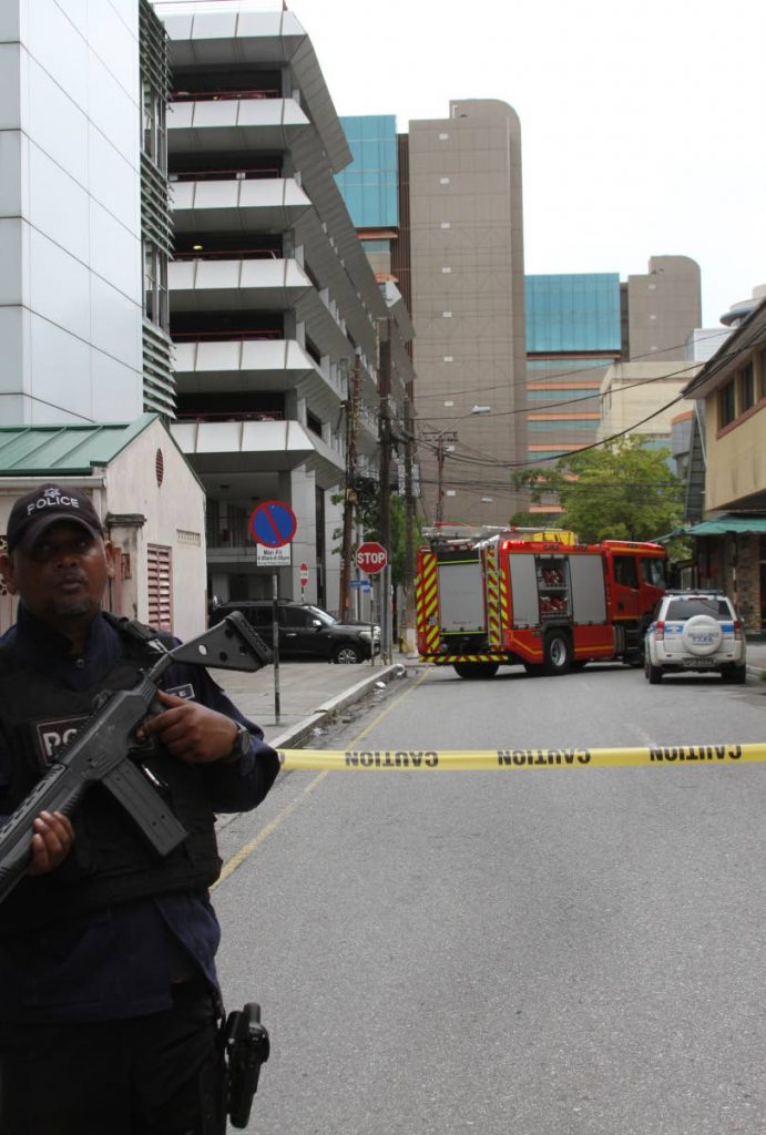 A policeman stands guard near the parkade in Port of Spain on Tuesday.  PHOTO BY ANGELO M MARCELLE - Angelo Marcelle