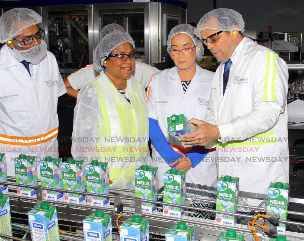 Minister of Trade and Industry Paula Gopee-Scoon, second from left, listens to Patricio Torres, marketing head of Nestlé Anglo Dutch Caribbean (Nestle Trinidad) while Elisa Doldron, head of Consumer Marketing, and Richard Seetaram, business integration manager look on during the tour of Nestlé Trinidad Ltd, corner Churchill Roosevelt Highway and Uriah Butler Highway, Valsayn, on Wednesday. - ROGER JACOB