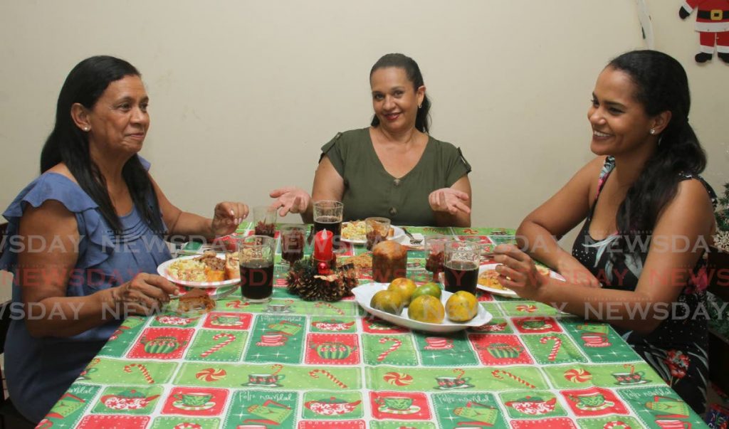 
La chef Ivonne Gascón, en el centro, comparte su almuerzo de Navidad con Vicky Rojas, a la izquierda, e India Matamoros. - AYANNA KINSALE