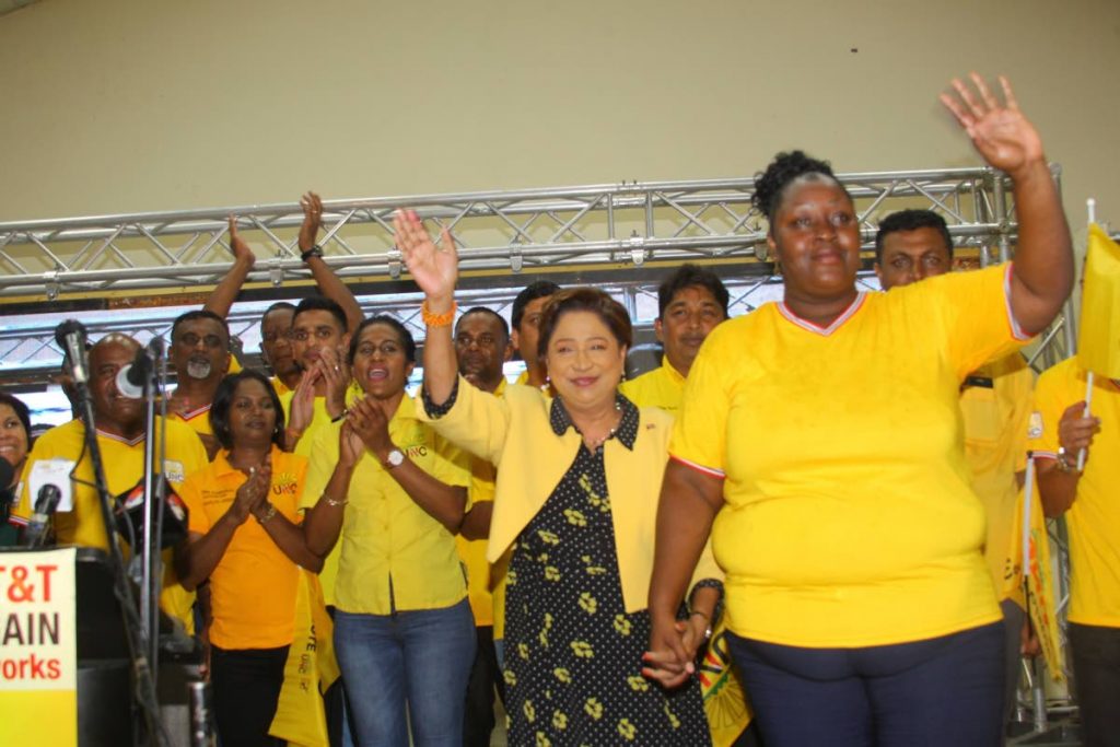 UNC Political Leader Kamla Persad-Bissessar, second from right, makes her way to the podium to speak to supporters at the Couva Multipurpose Facility last night. - ROGER JACOB