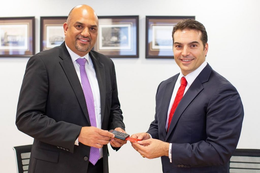 Anand Pascal, president, Guardian Life of the Caribbean, and Stephen Bagnarol, senior vice president and managing director, Scotiabank demonstrate the mobile point of sale devices. - 