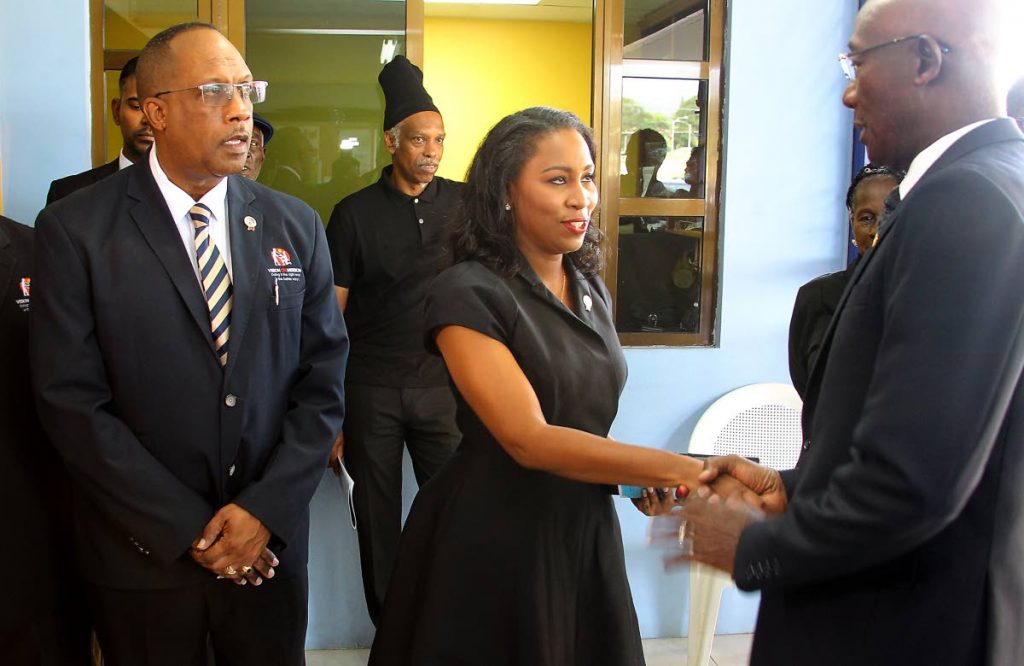 Prime Minister Dr Keith Rowley, left, greets Wayne Chance’s widow, Giselle Chance, as executive director of Vision on a Mission Gerald Wilson looks on at Chance’s funeral at Divine Encounter Ministries International, Ragoo Road, D’Abadie, yesterday. - ROGER JACOB