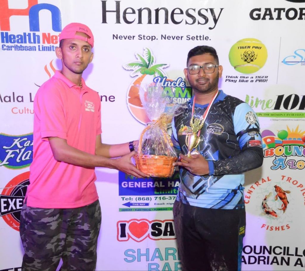 Heavy Hitters’ Harvey Rampersad, right, presented with his Man of the Final prize from an official at the Hennessy Super 6’s final, on Sunday. - 
