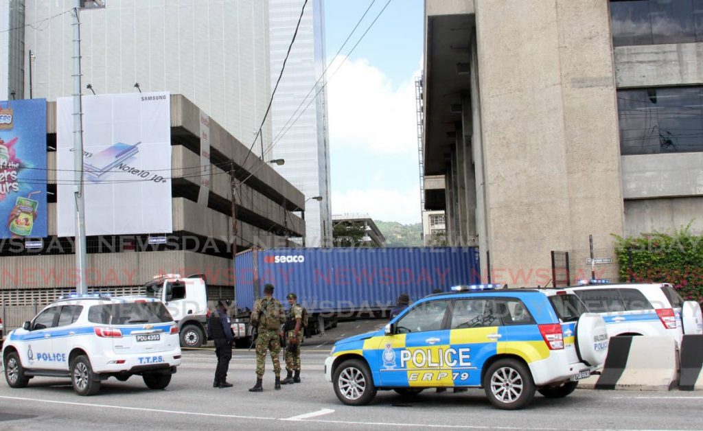 Members of the protective services secure the area around the Central Bank, Port of Spain where trailers carrying the new one hundred dollar bills are off loaded on Saturday December 7, 2019. - ANGELO MARCELLE