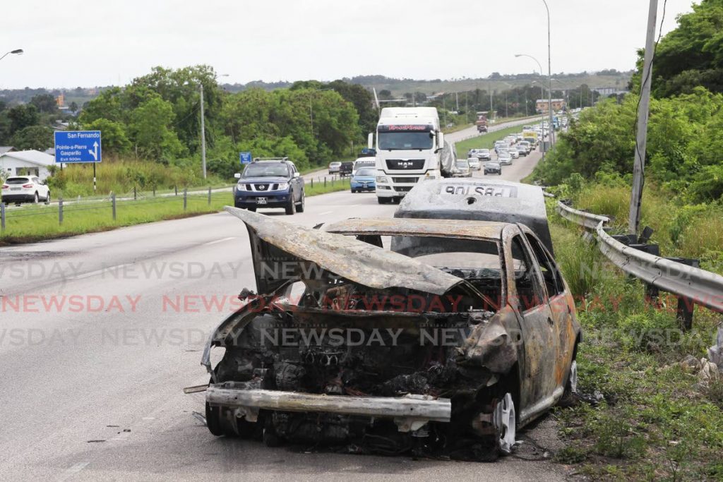 The remains of the car which burst into flames on the northbound lane of the Solomon Hochoy Highway on Thursday morning.  PHOTO BY LINCOLN HOLDER - Lincoln Holder