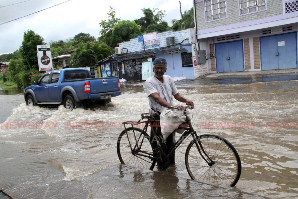 Jaggan Deo, 80, looks at the floods in his Digity and Wilson Road, Barrackpore community 
on Wednesday.  
PHOTO BY VASHTI SINGH - Vashti Singh