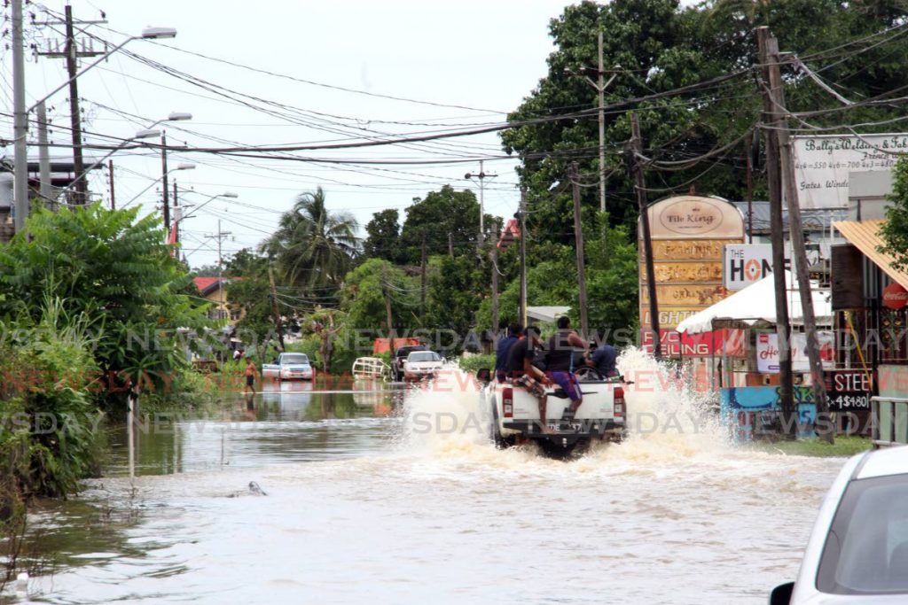 Residents get a ride on a van to go through floodwaters in a community in south Trinidad on Thursday. - Vashti Singh