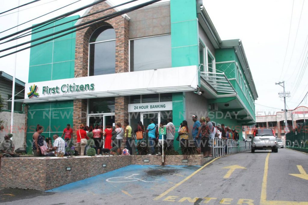 In this December 13 file photo, customers wait in lines to enter First Citizens' bank in Penal to exchange old $100 notes for the new polymer ones. December 31 is the last day First Citizens will accept the old bills. - Lincoln Holder