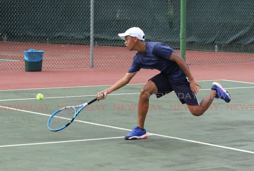 Alex Chin returns the ball to Daniel Jeary (not in photo) during the RBC Junior Tennis Tournament at Country Club, Maraval on Saturday. Chin won 4-1,4-2. - Ayanna Kinsale
